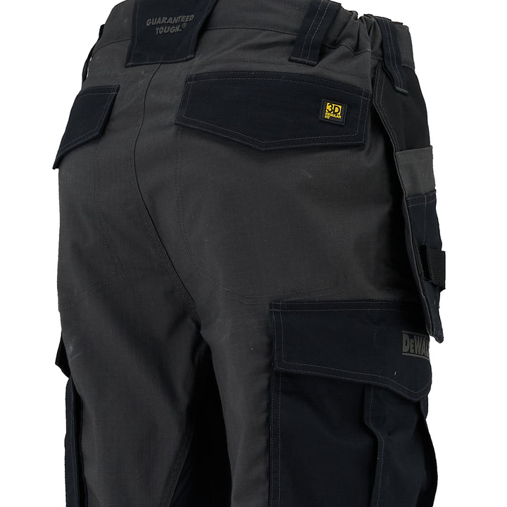 Black work pants with multiple pockets and visible branding on a white background