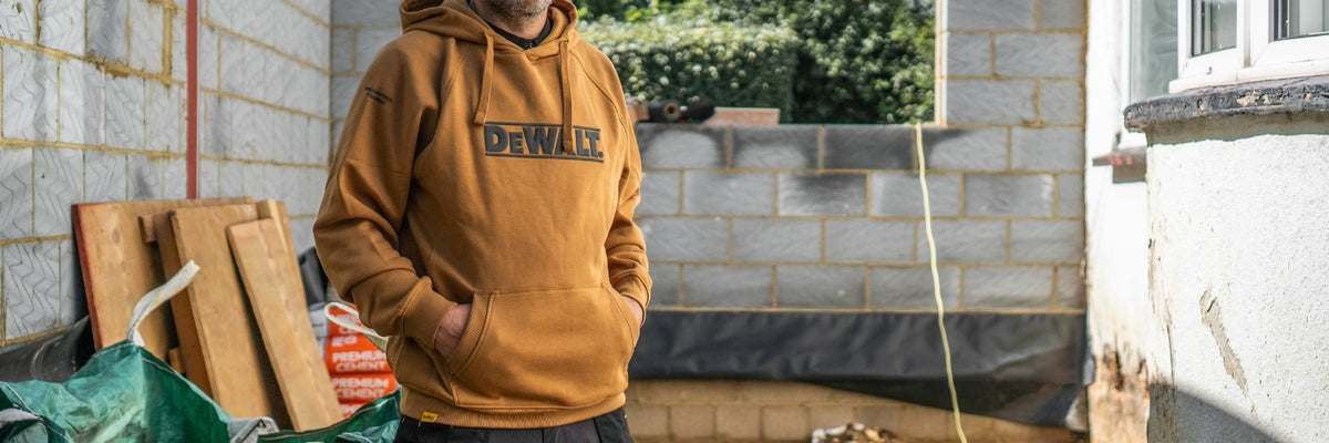 DEWALT branded hoodie on a model with a construction site background