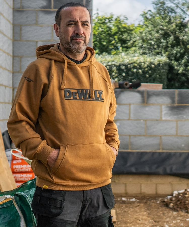 DEWALT branded hoodie on a model with a construction site background